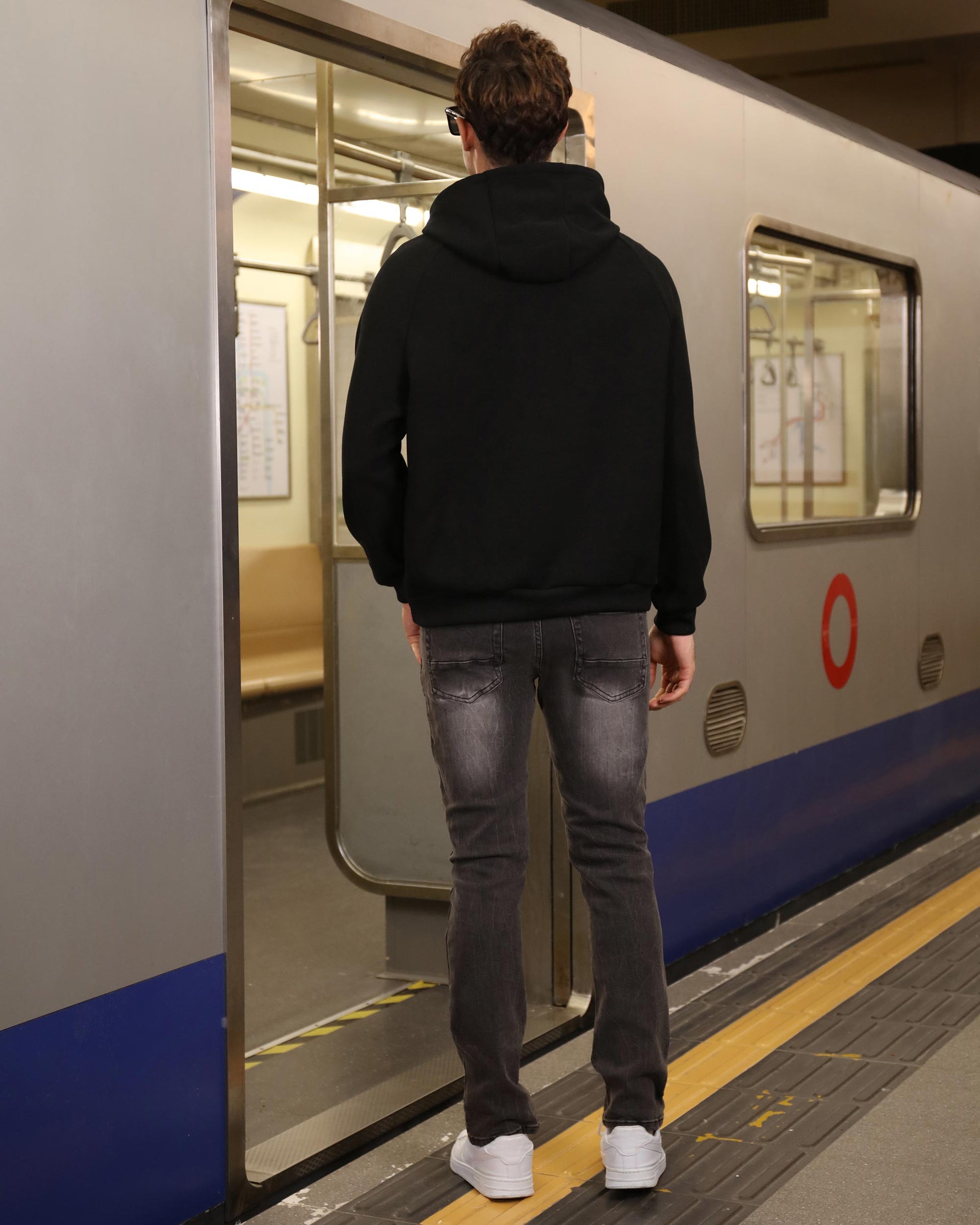 Man wearing Logeqi stylish straight leg jeans standing at subway train door in casual outfit