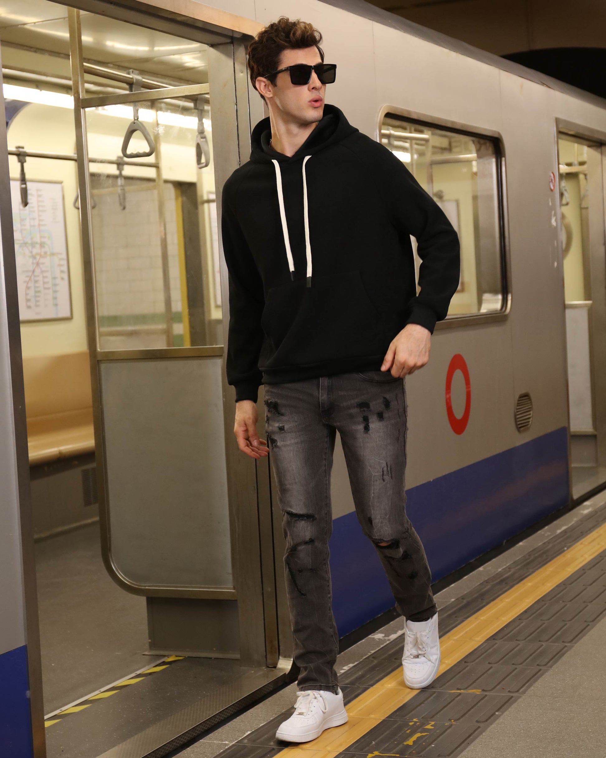 Man wearing Logeqi stylish straight leg jeans with distressed details walking by subway train