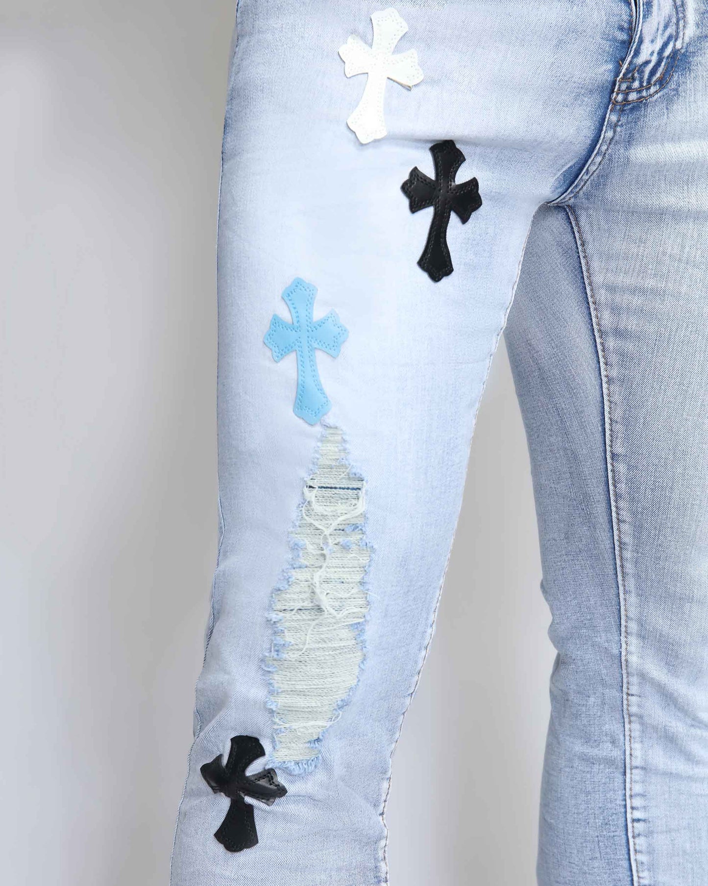 Trendy distressed jeans by Logeqi featuring decorative cross patches and stylish rips for a modern look