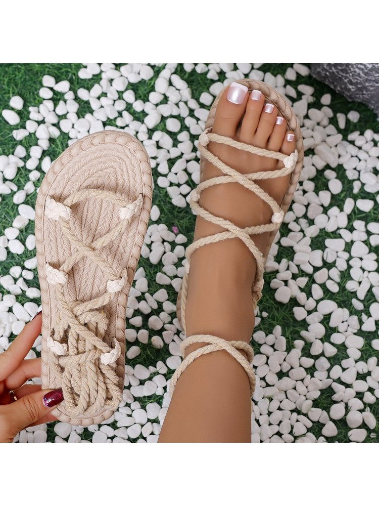 Beige tropical wrap sandals for women with braided straps on foot and hand holding one sandal