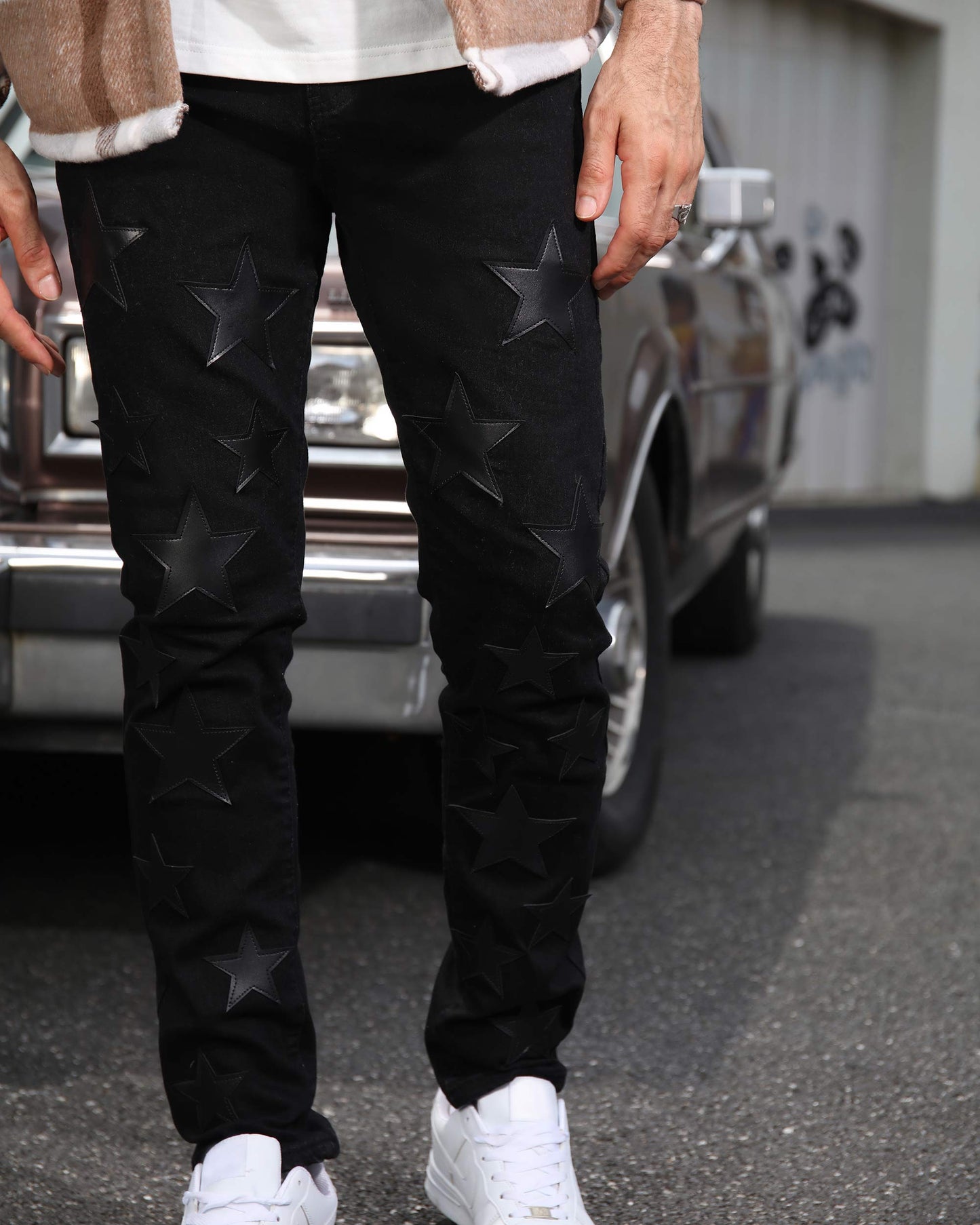 Logeqi black straight leg jeans with embossed star patterns worn with white sneakers