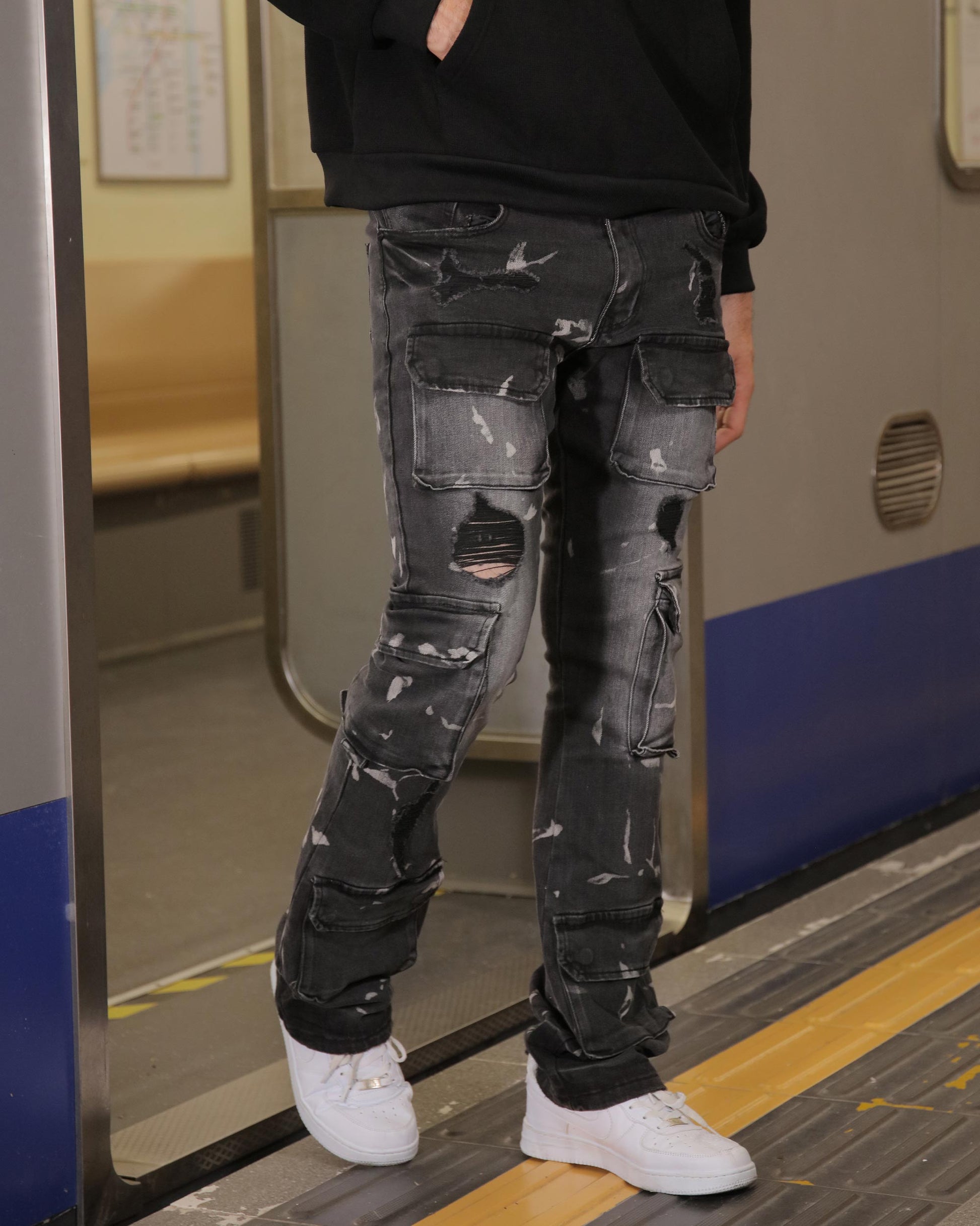 Logeqi distressed black cargo jeans with multiple pockets and rips worn with white sneakers