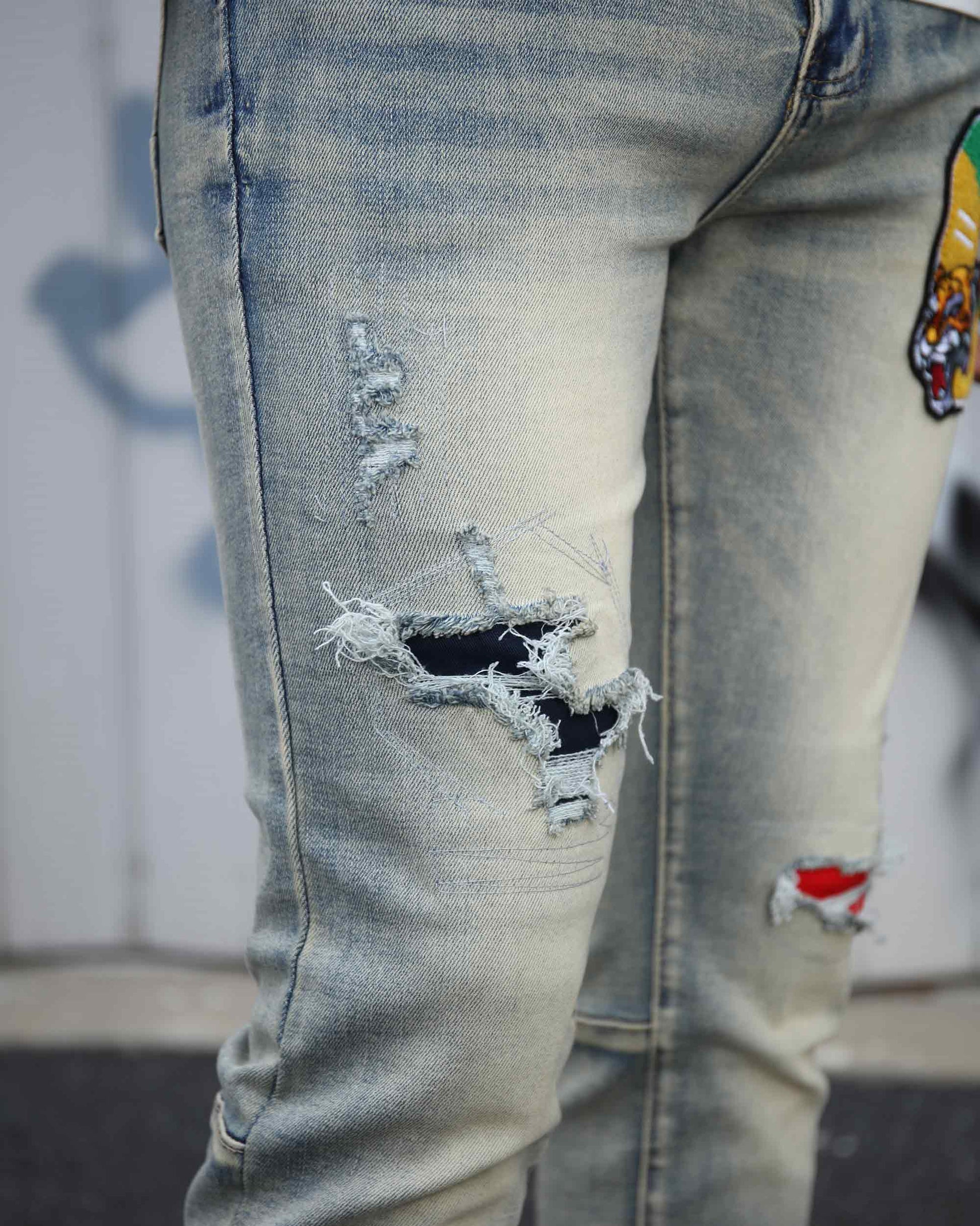 Logeqi distressed light wash jeans featuring ripped and frayed details on the front thigh