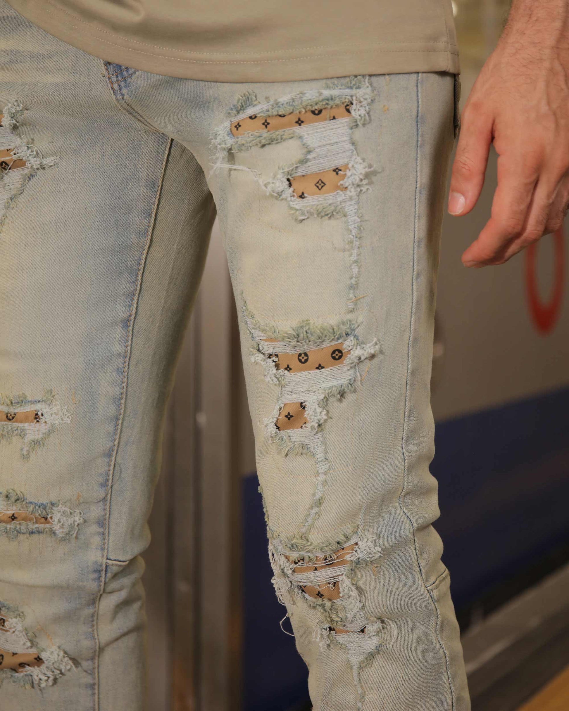 Logeqi distressed ripped blue jeans close-up showing torn patches and frayed edges on light denim