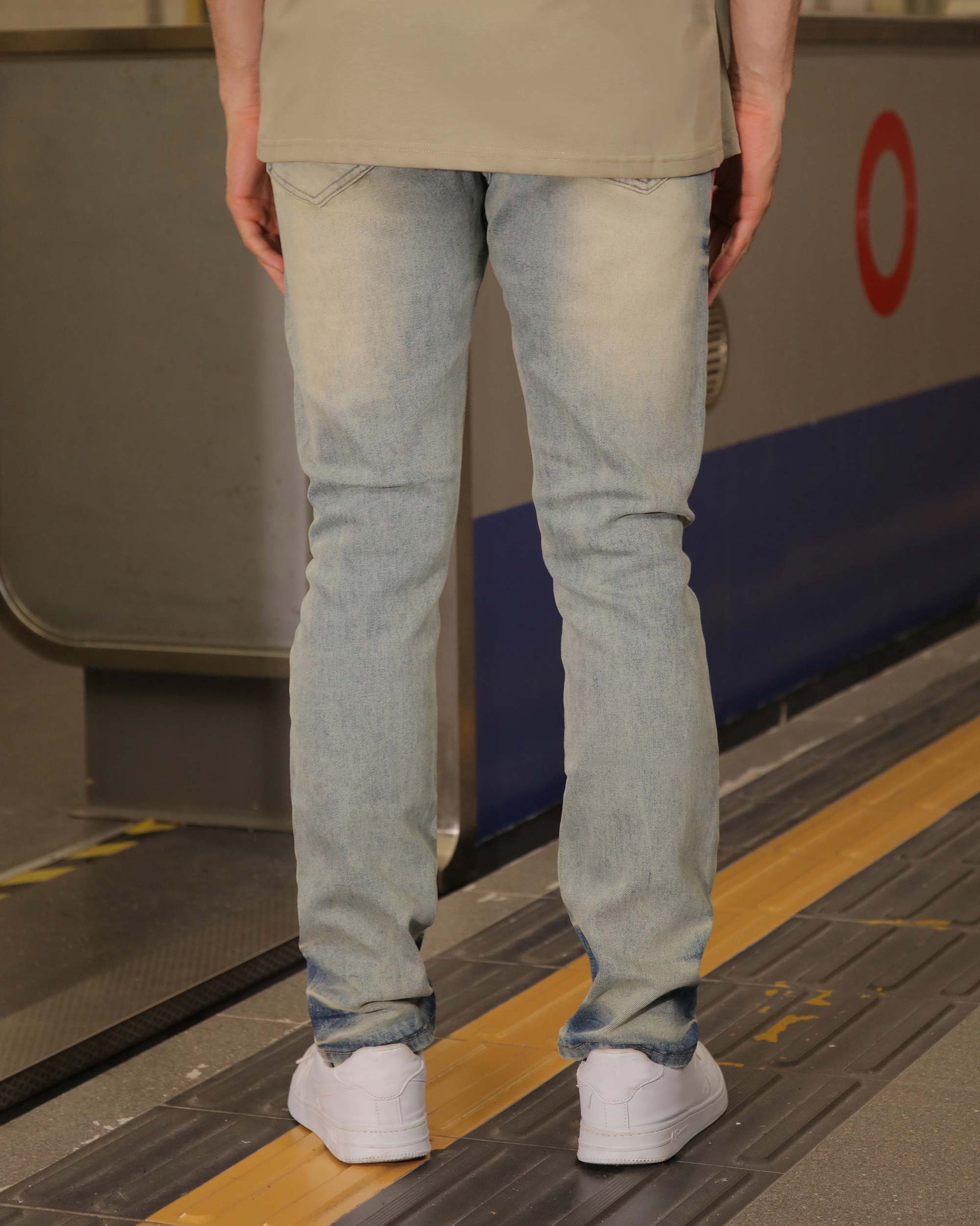Logeqi light wash graffiti streetwear jeans shown from the back with white sneakers