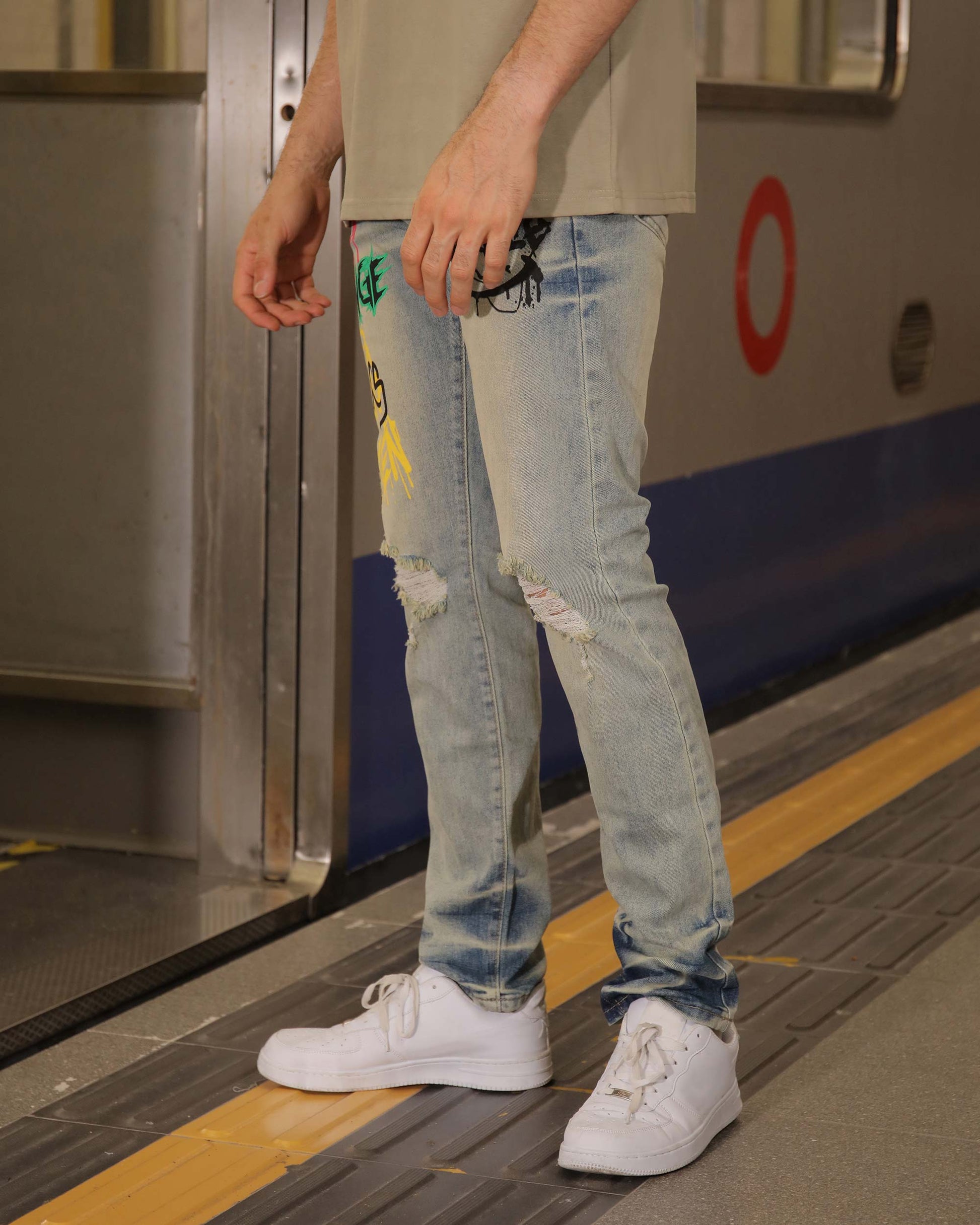 Logeqi light blue ripped jeans with colorful graffiti streetwear jeans design worn with white sneakers
