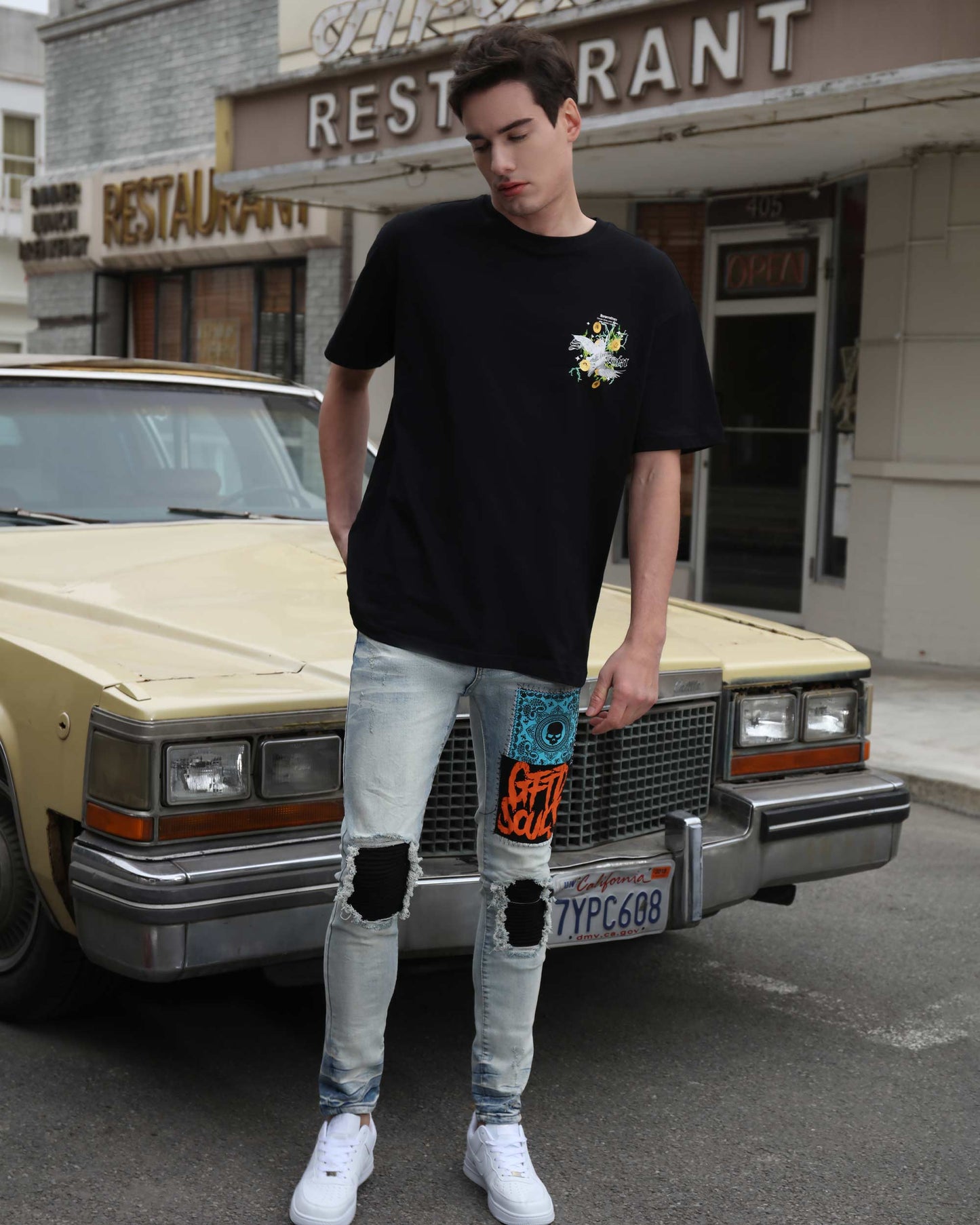 Men's light wash graffiti jeans by Logeqi featuring patch details and distressed knees