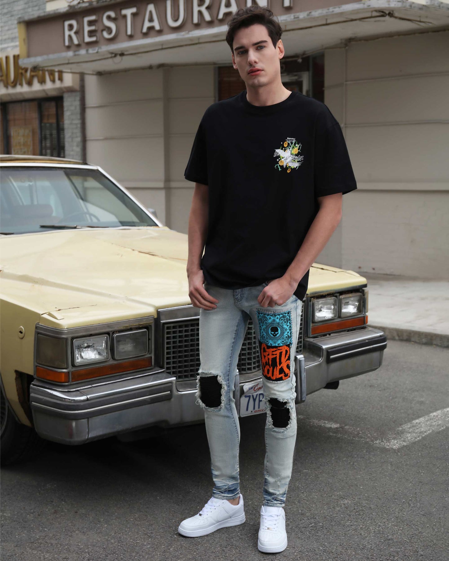 Logeqi light wash graffiti jeans with colorful patches and distressed knees worn by male model
