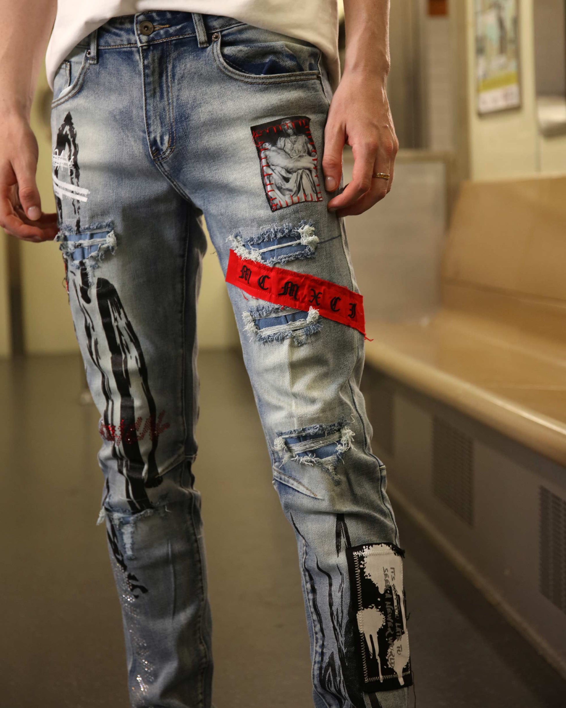 Logeqi medium wash ripped jeans with graphic patches and distressed detailing on slim fit legs