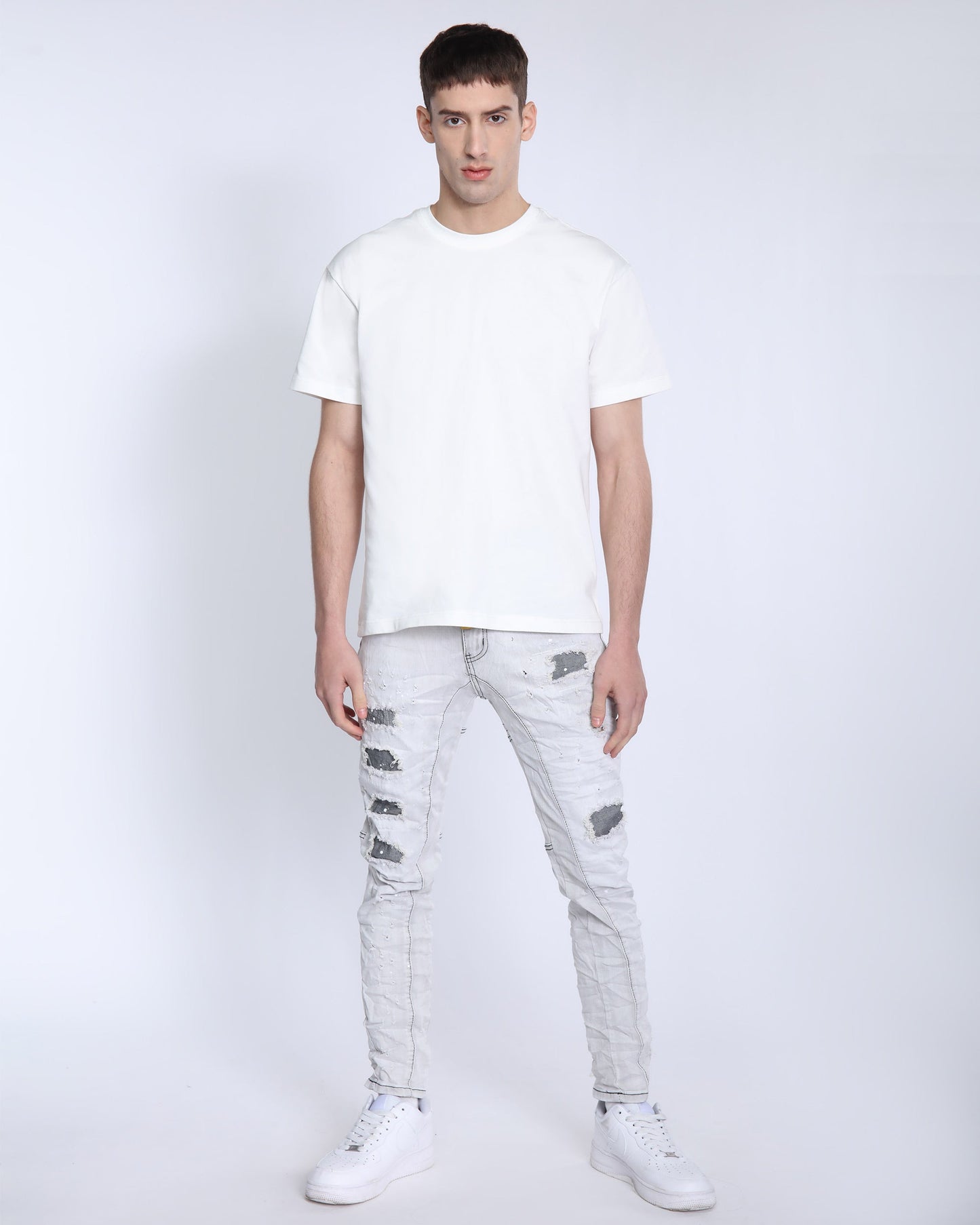 Logeqi slim fit gray distressed jeans worn by male model with white t-shirt and sneakers