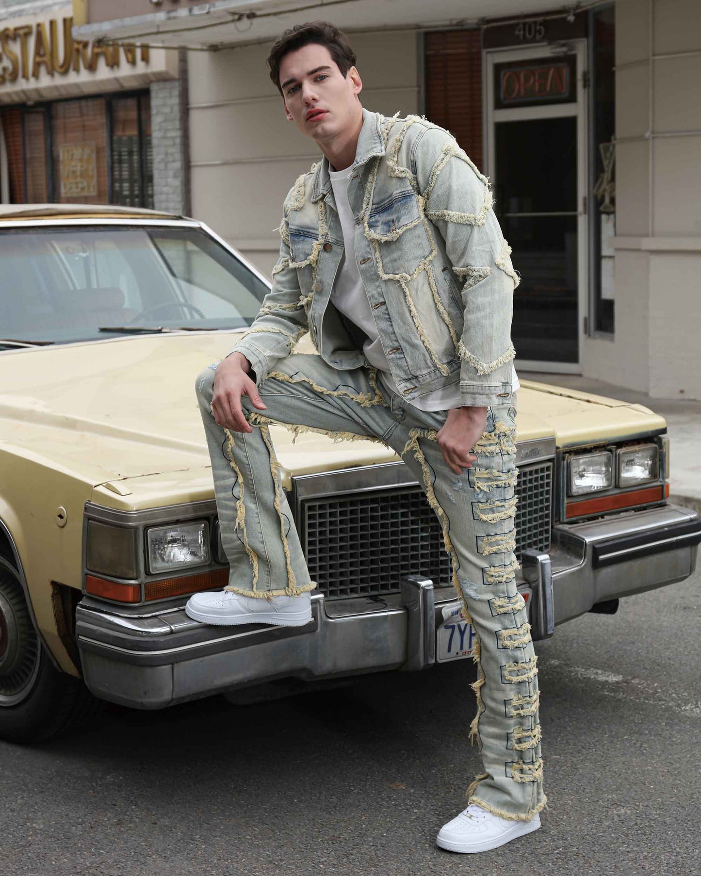 Logeqi vintage blue stacked jeans worn by male model leaning on vintage car