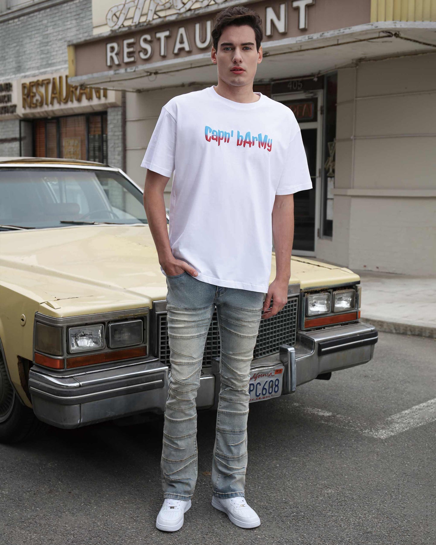 Logeqi vintage distressed blue jeans worn by man standing in front of vintage car on city street