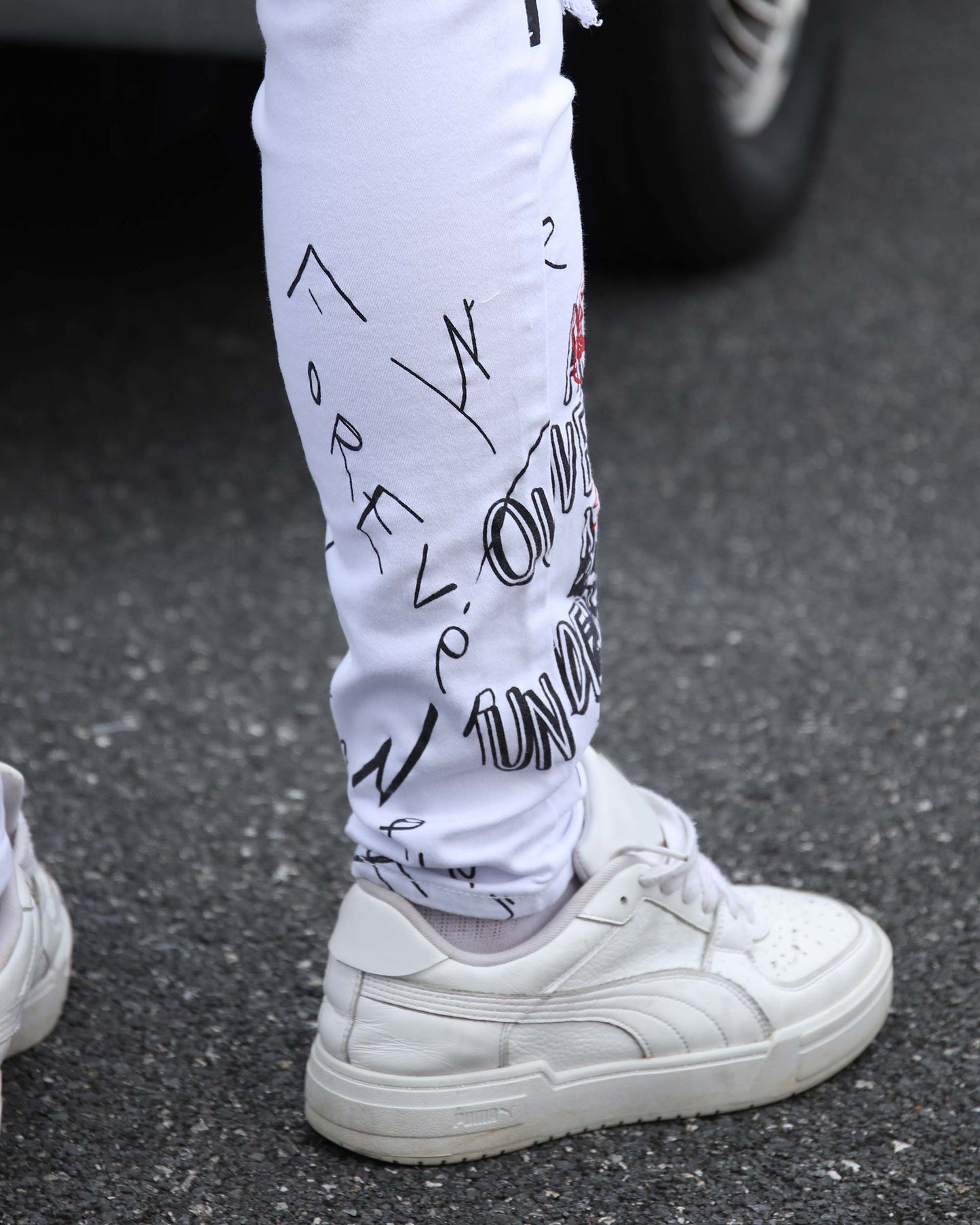 Logeqi white ripped jeans graffiti featuring stylish designs, paired with white sneakers on a street