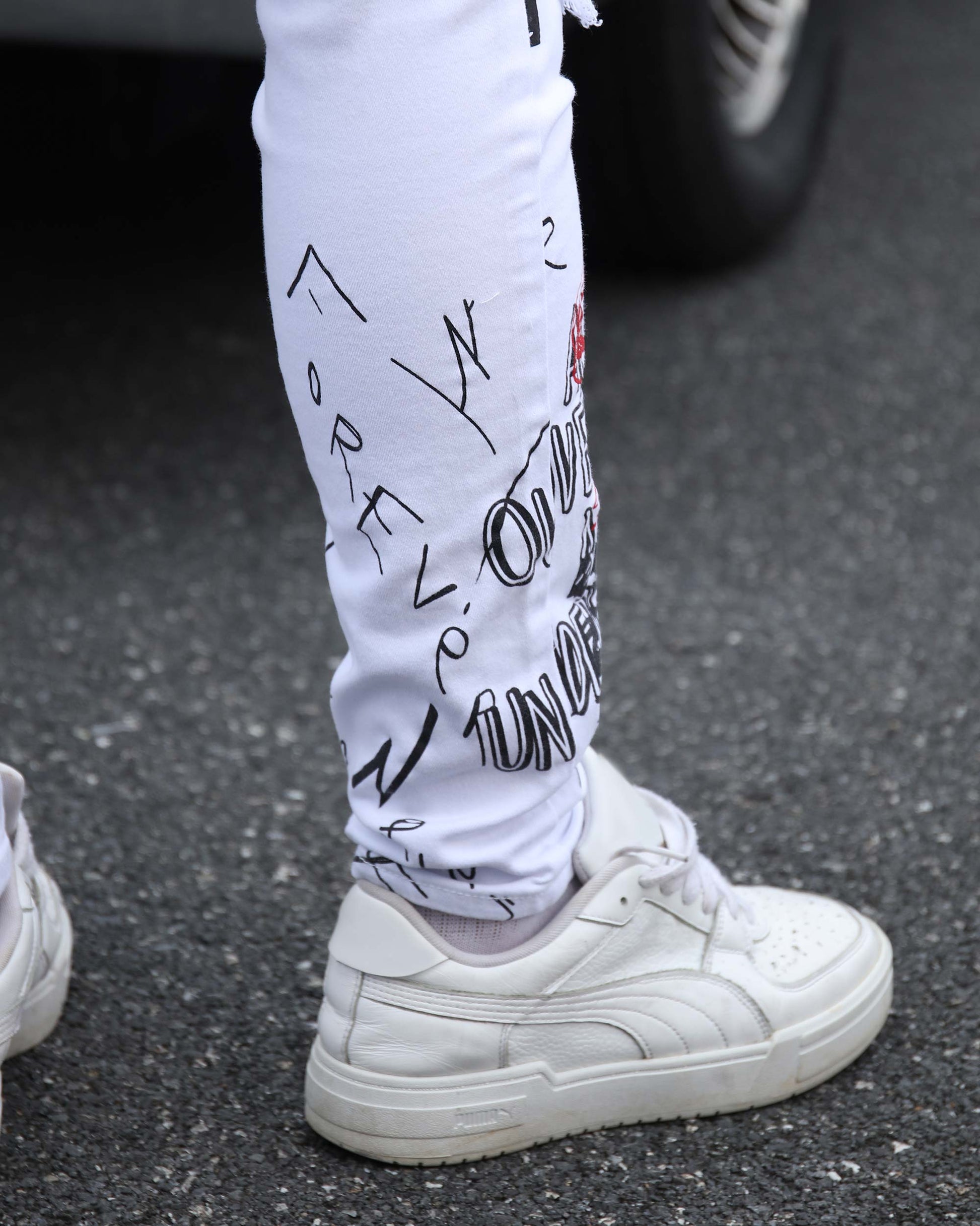 Logeqi white ripped jeans graffiti featuring stylish designs, paired with white sneakers on a street