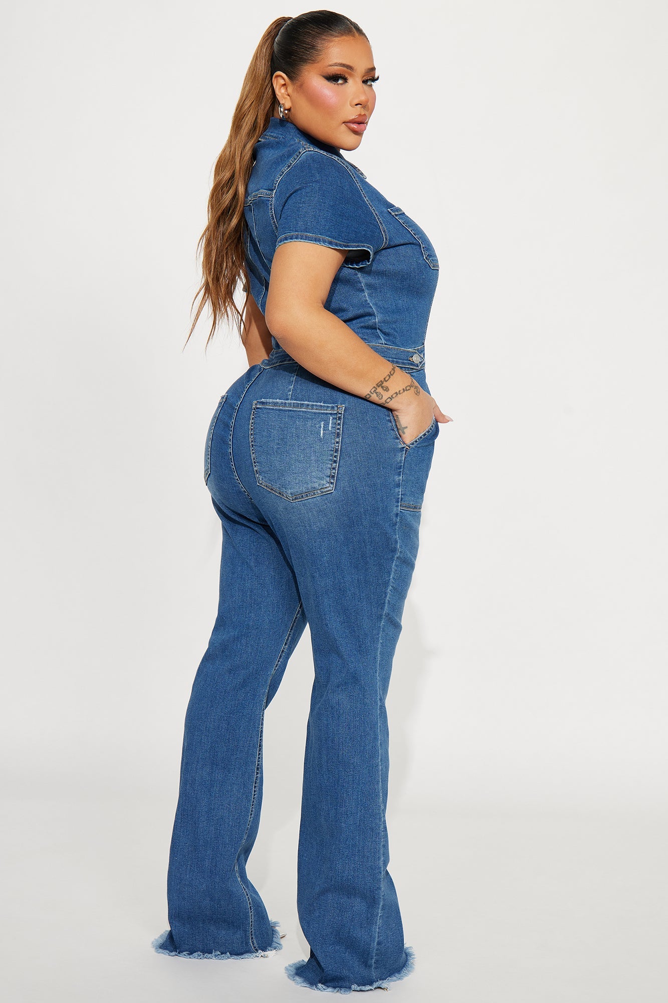 Stylish women's denim jumpsuit medium wash featuring a fitted design and flared legs