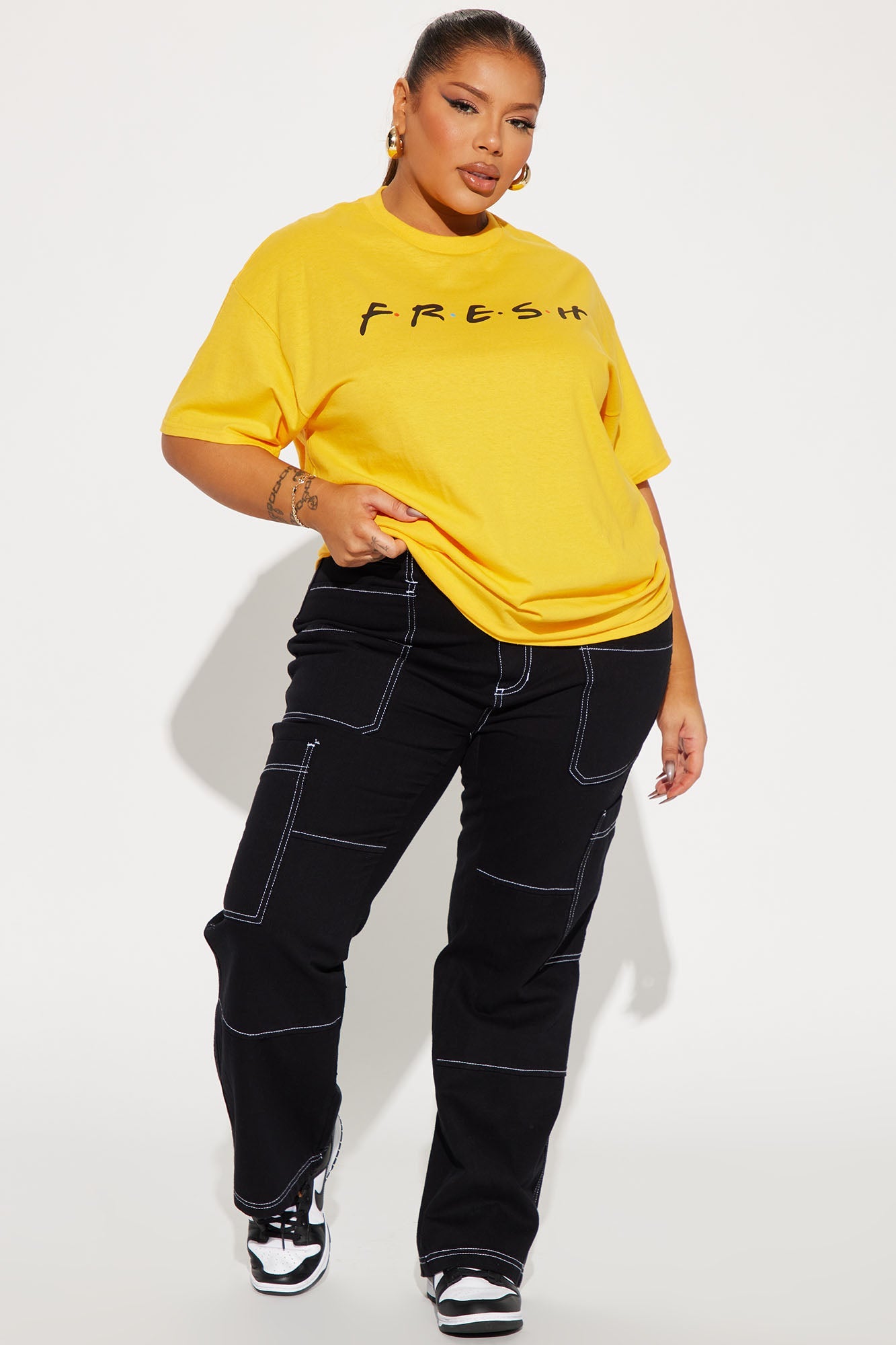 Yellow graphic t-shirt for women paired with black cargo pants for a casual look