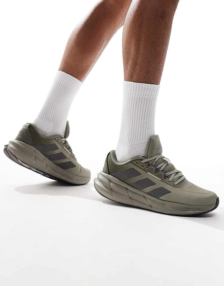 adidas Questar 3 olive green sneakers worn by a model with white socks for a stylish athletic look