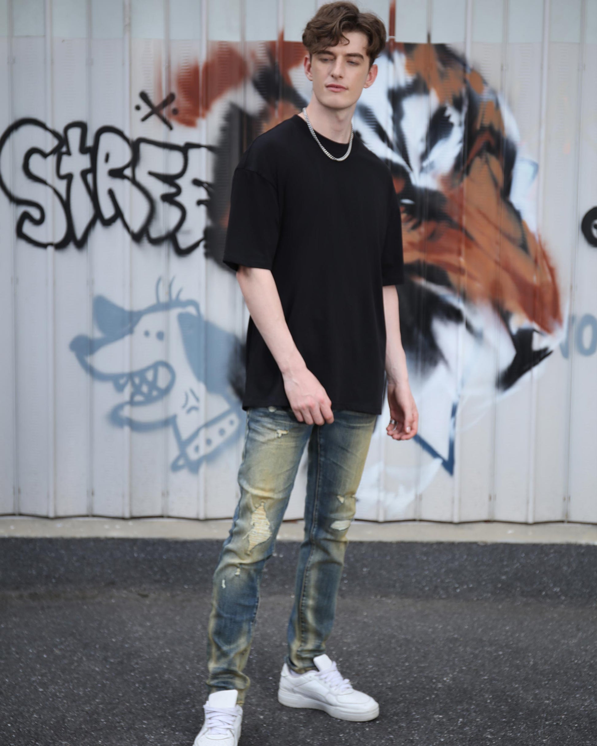 Logeqi black cotton t-shirt worn by a model with distressed jeans for a casual street style look