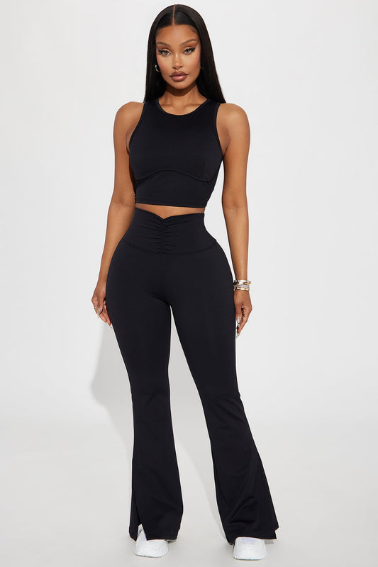Model wearing black flare yoga pants for women paired with a matching crop top