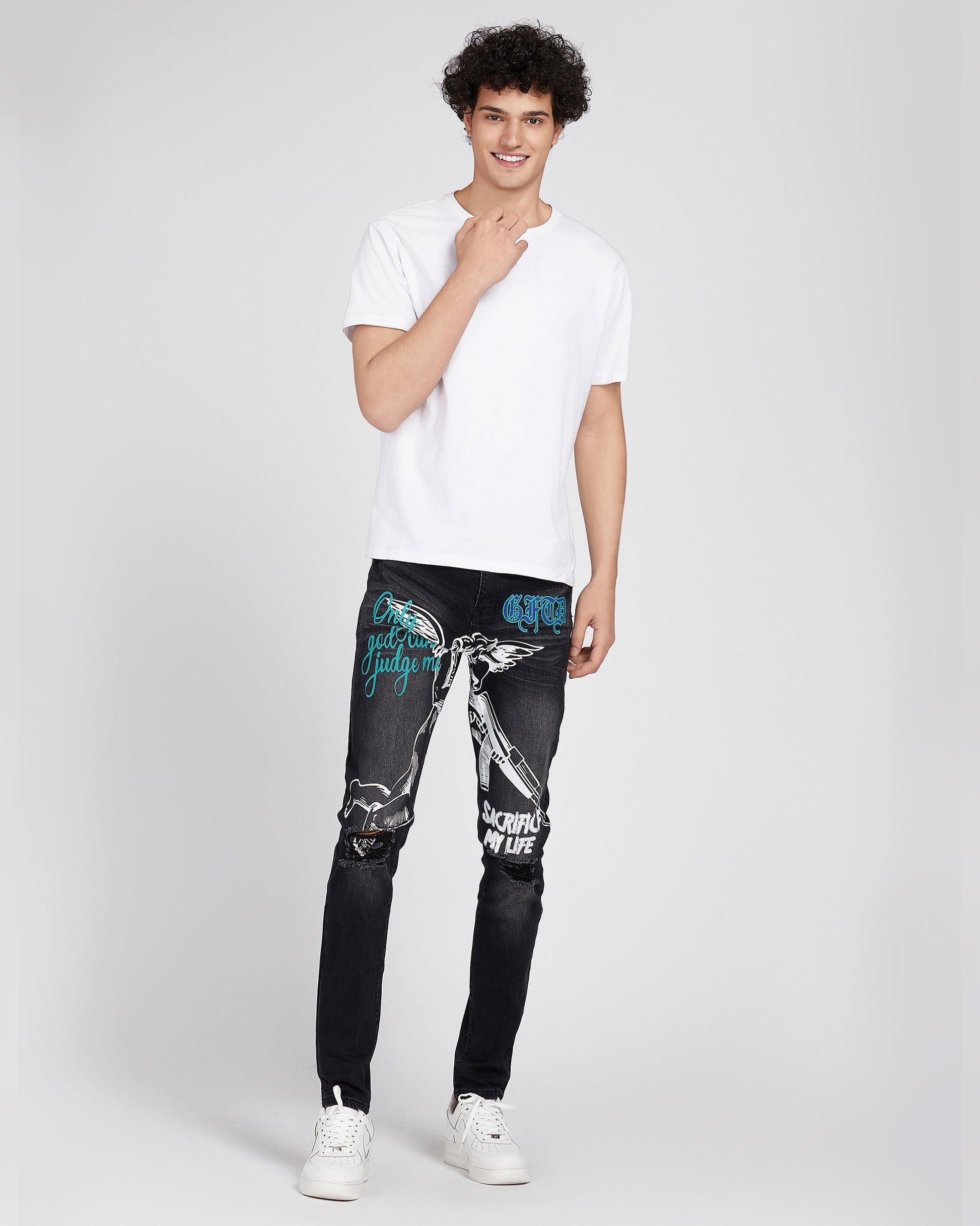 Logeqi black ripped graffiti jeans with white and blue graphic prints worn by male model