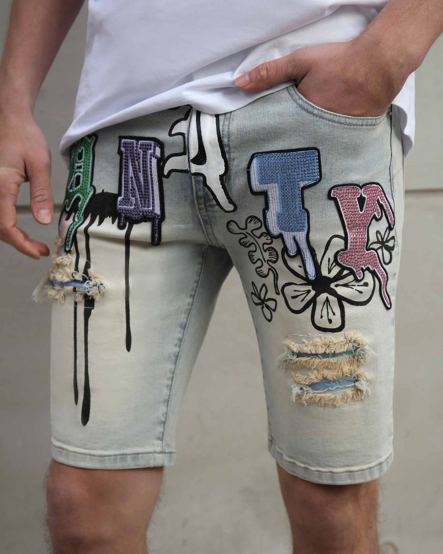 Logeqi distressed graffiti denim shorts with colorful patched letters and ripped details on light wash fabric