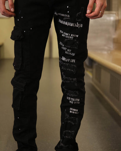 Logeqi black spray paint detail jeans with white text and distressed patches on the legs