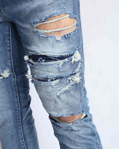 Logeqi Cashew Blossom patched jeans featuring distressed detailing and ripped accents
