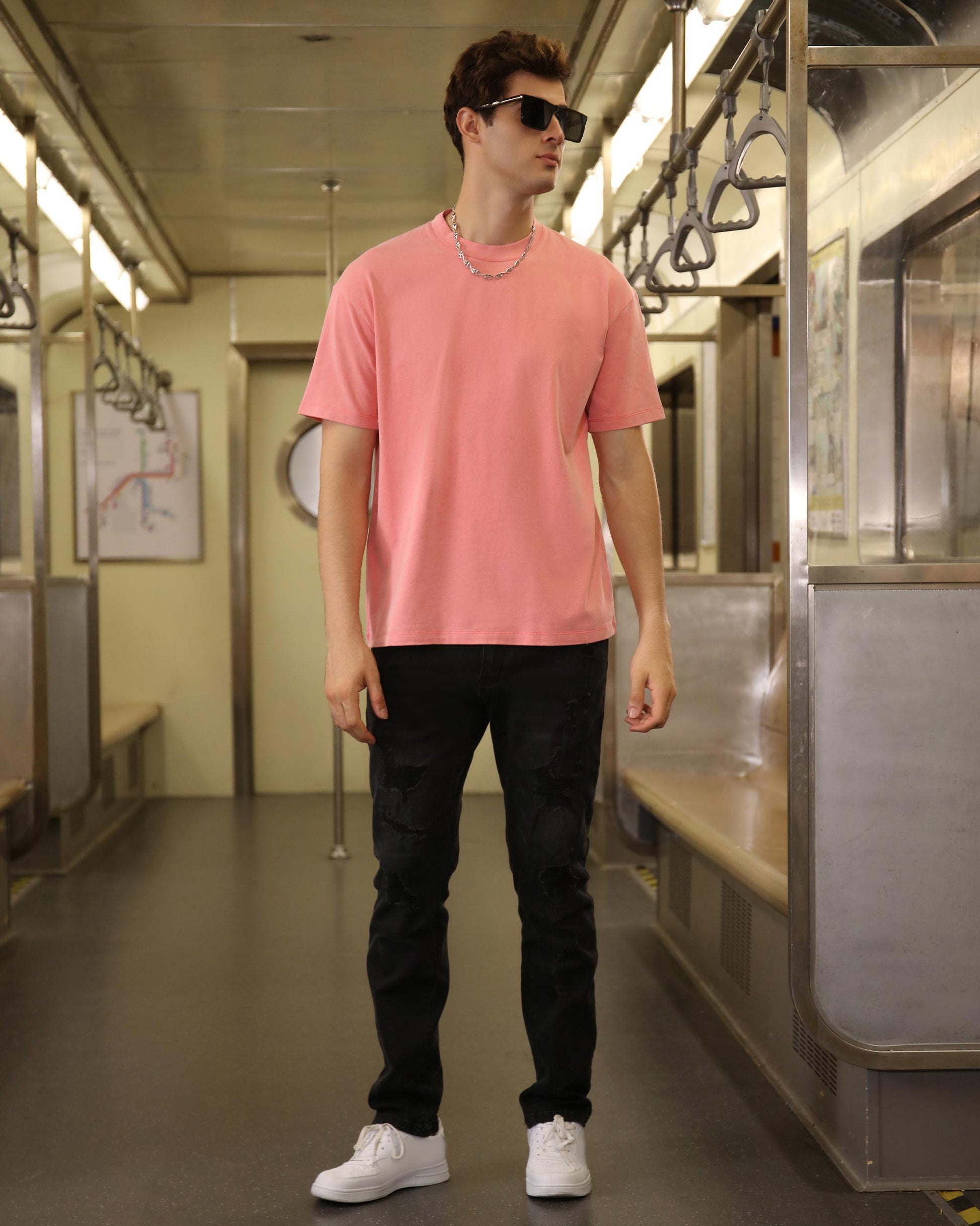 Logeqi classic pink t-shirt displayed on a model in a subway setting, paired with black pants
