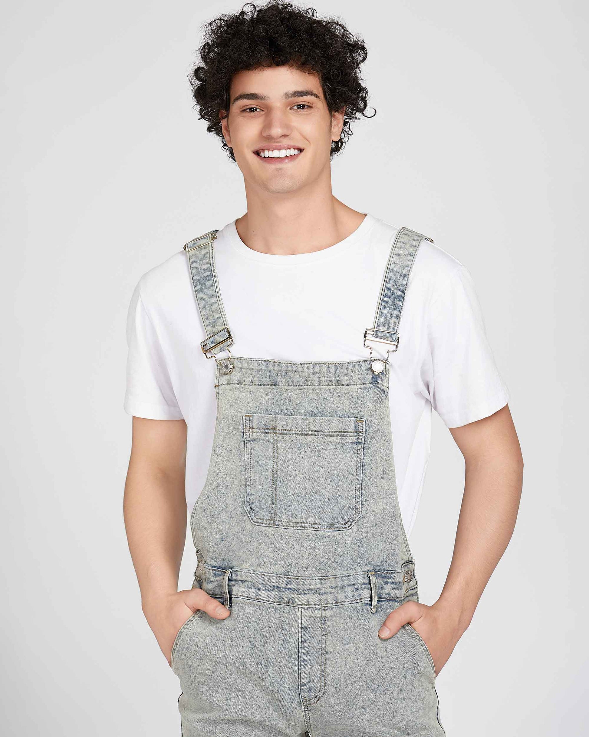 Logeqi classic ripped overalls in light denim worn by a smiling man with curly hair and white t-shirt