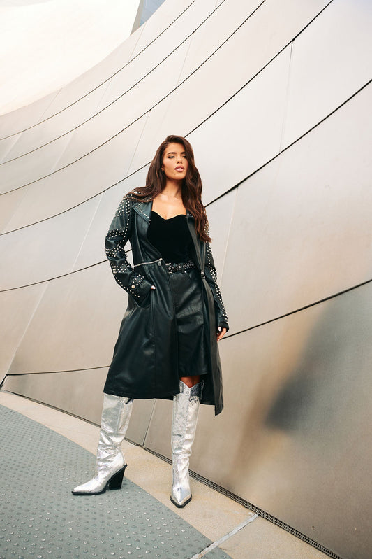 Fashion Nova convertible trench coat black with studded details worn over a black outfit and silver boots