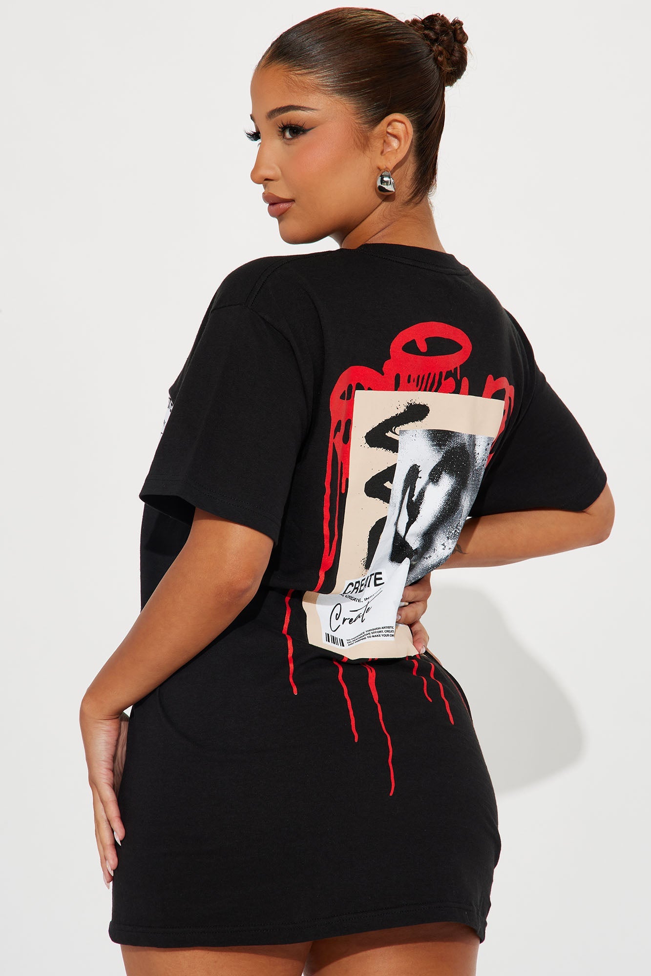 Model wearing a black Fashion Nova create what you love graphic tee with oversized fit and unique design