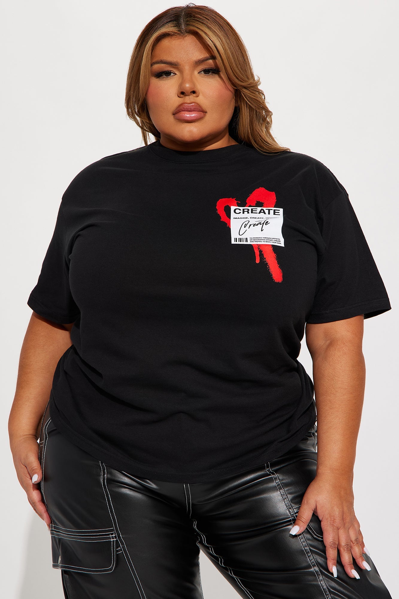 Woman wearing a black create what you love graphic tee with a stylish design by Fashion Nova