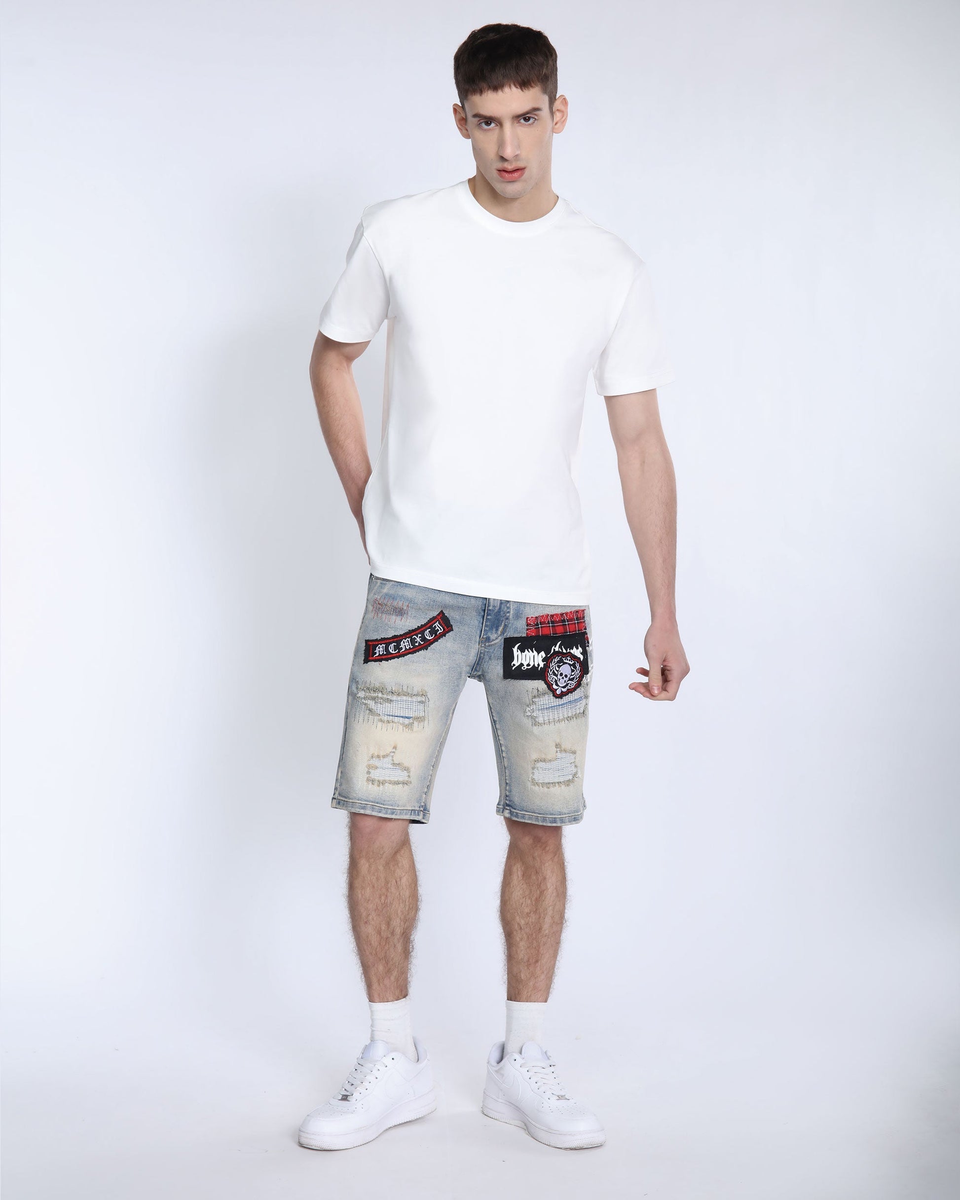 Logeqi distressed denim shorts men with patched design worn with white t-shirt and sneakers