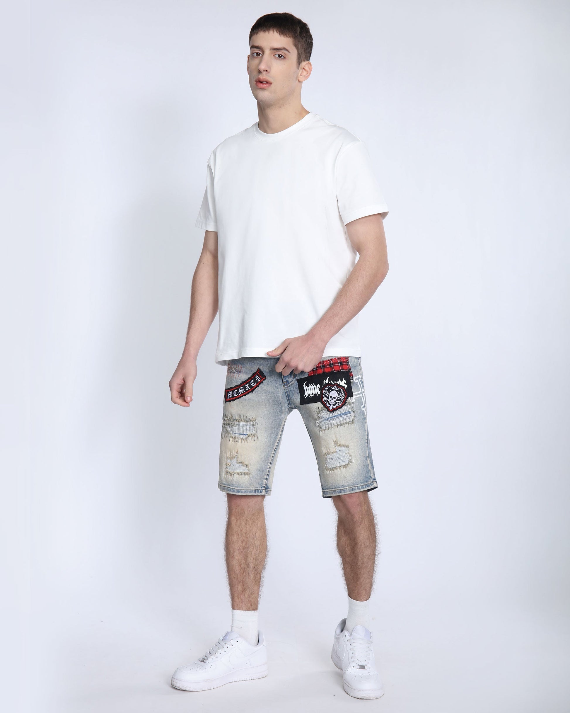 Logeqi distressed denim shorts men with patch designs worn by male model in white t-shirt and sneakers