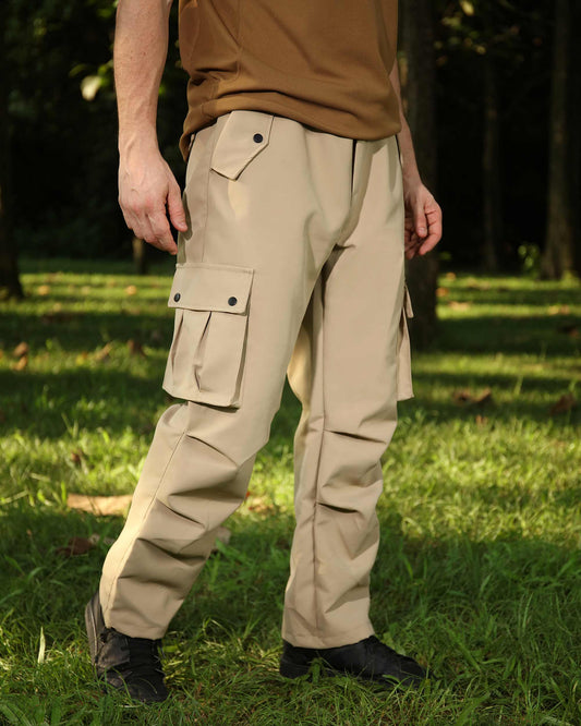 Logeqi durable outdoor cargo pants in beige with multiple pockets worn in a grassy forest setting