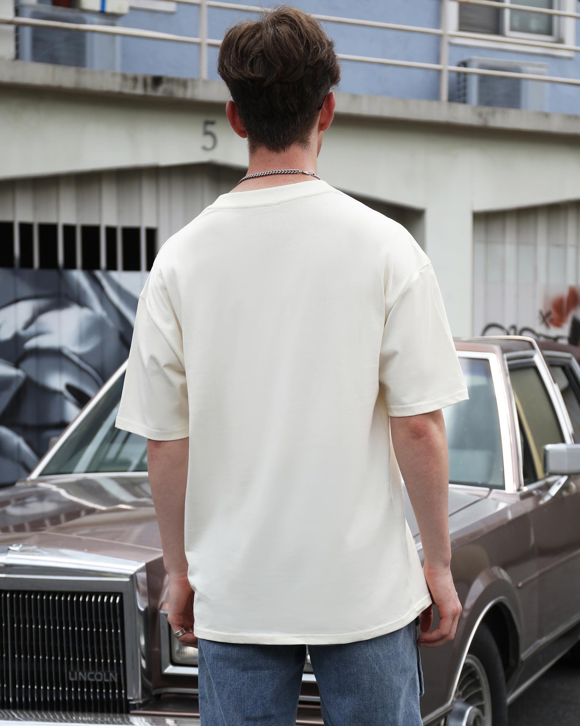 Back view of a Logeqi essential solid t-shirt in cream color, perfect for casual wear
