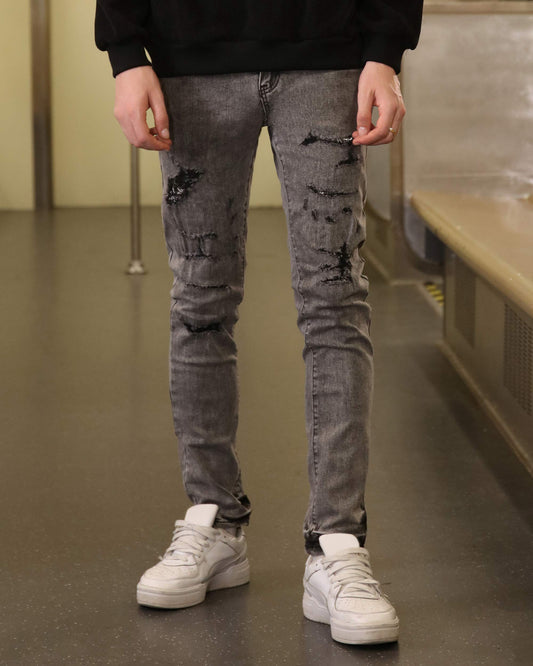 Logeqi gray ripped jeans men styled with white sneakers and black sweatshirt in urban setting