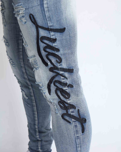 Logeqi light wash blue ripped jeans featuring stylish embroidered 'Luckiest' detail on the leg