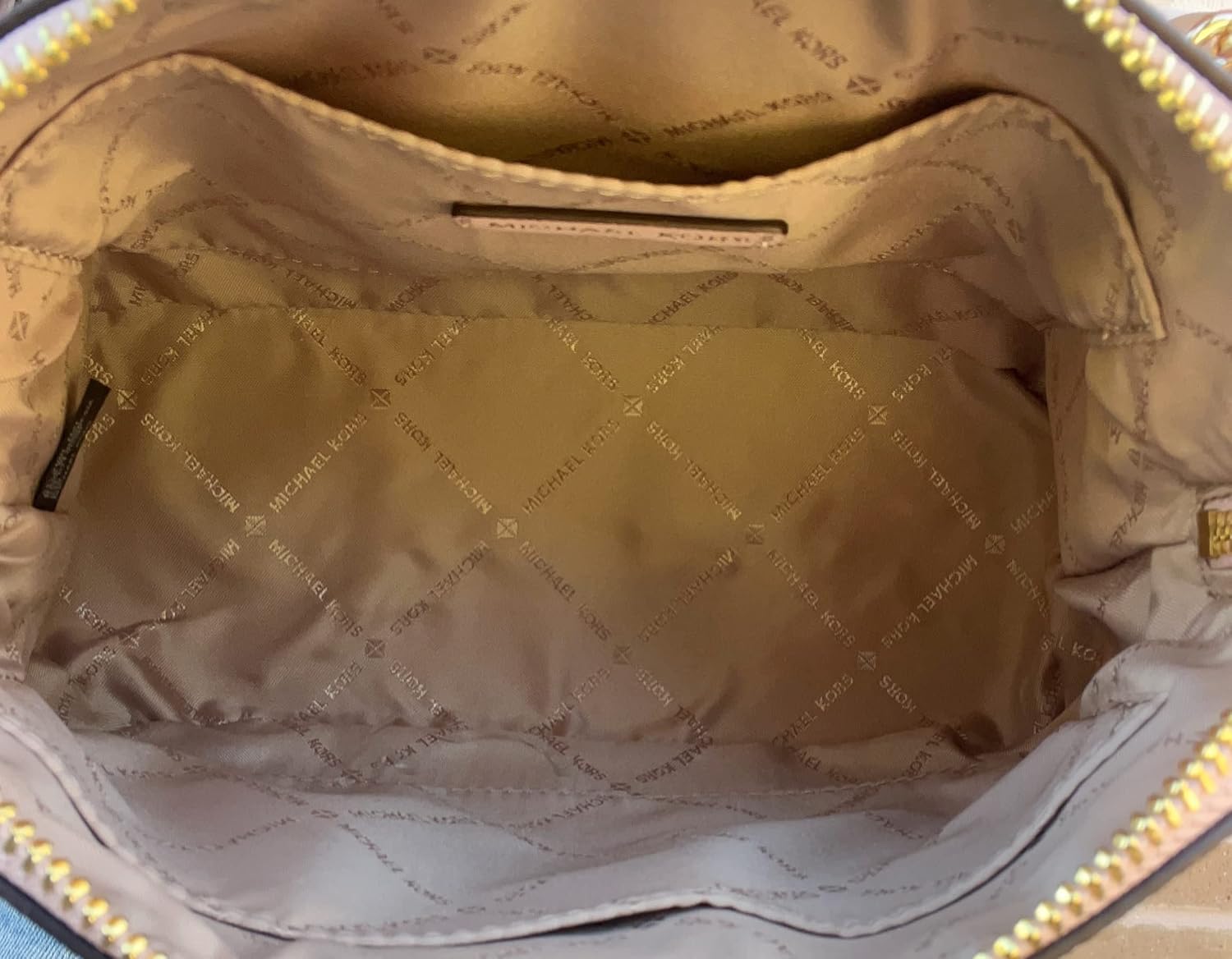 Inside view of a Michael Kors crossbody leather handbag with spacious interior and logo lining