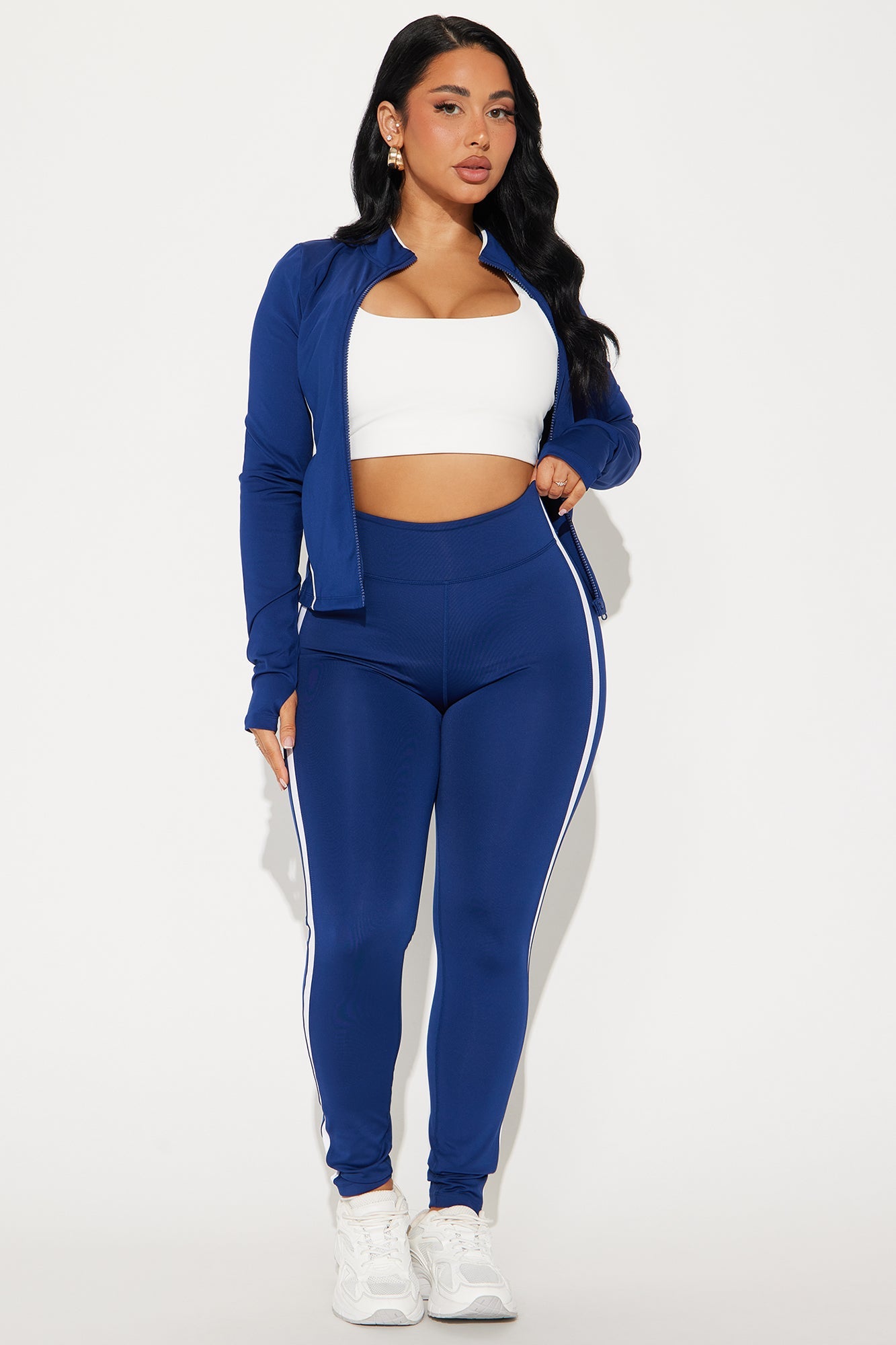 Midnight blue active leggings with white side stripes, paired with a fitted white crop top and matching jacket