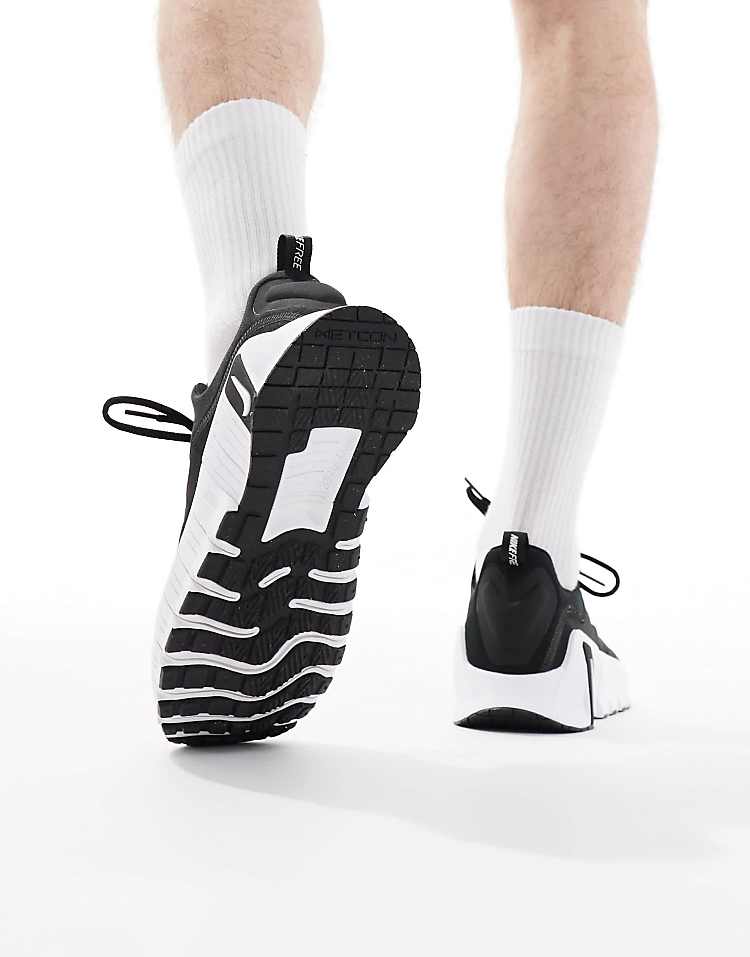 Nike Free Metcon 6 black white sneakers with detailed outsole viewed from behind on a model's feet