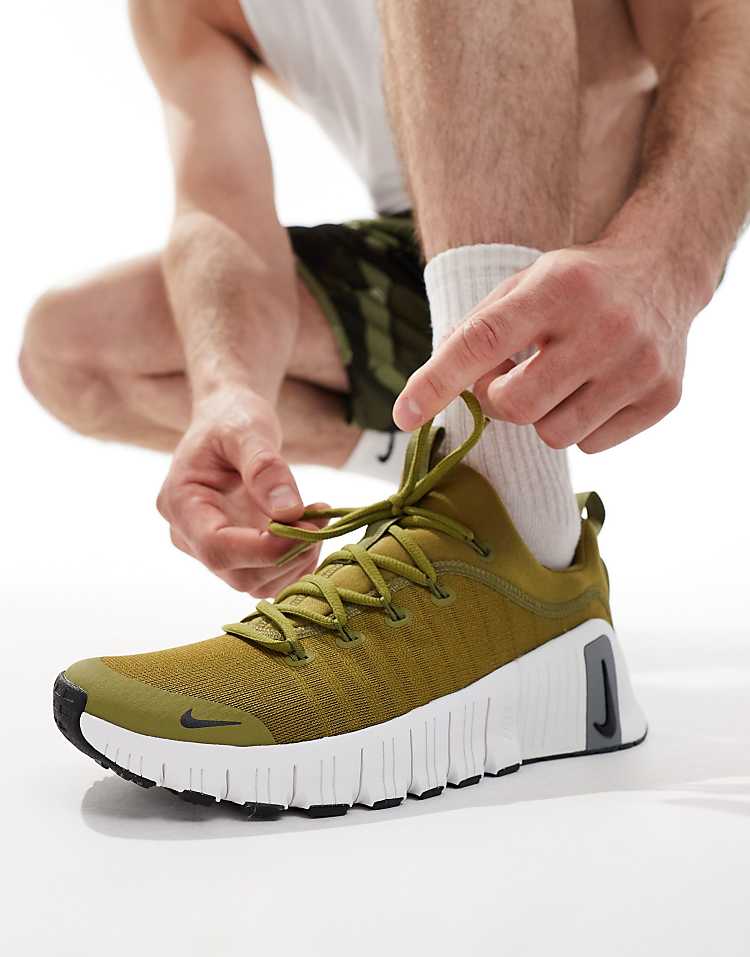 Nike Free Metcon 6 unisex sneakers in green being laced up, ideal for versatile training