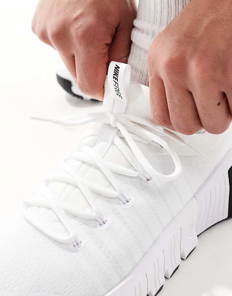 Nike Free Metcon 6 unisex sneakers in white with a person tying the laces for a snug fit
