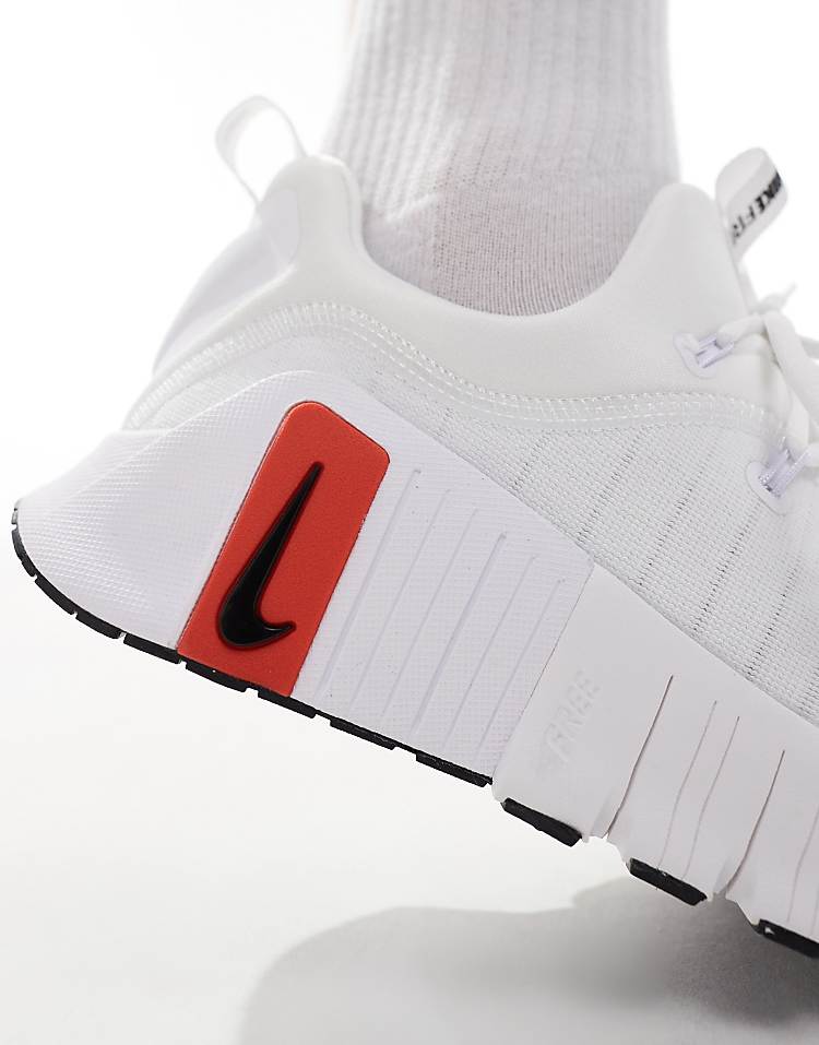 Close-up of Nike Free Metcon 6 unisex sneakers featuring a white design and red accents