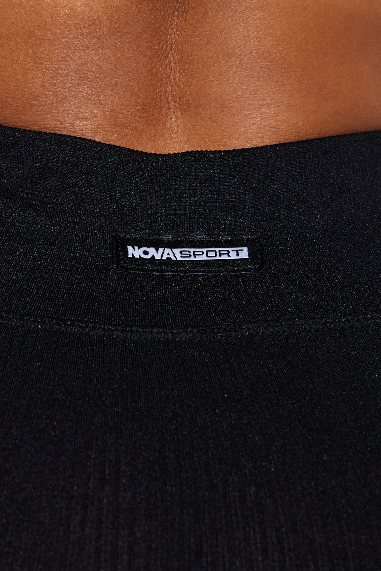 Close-up of Fashion Nova Nova Sport black seamless active leggings with logo and stretchy fabric