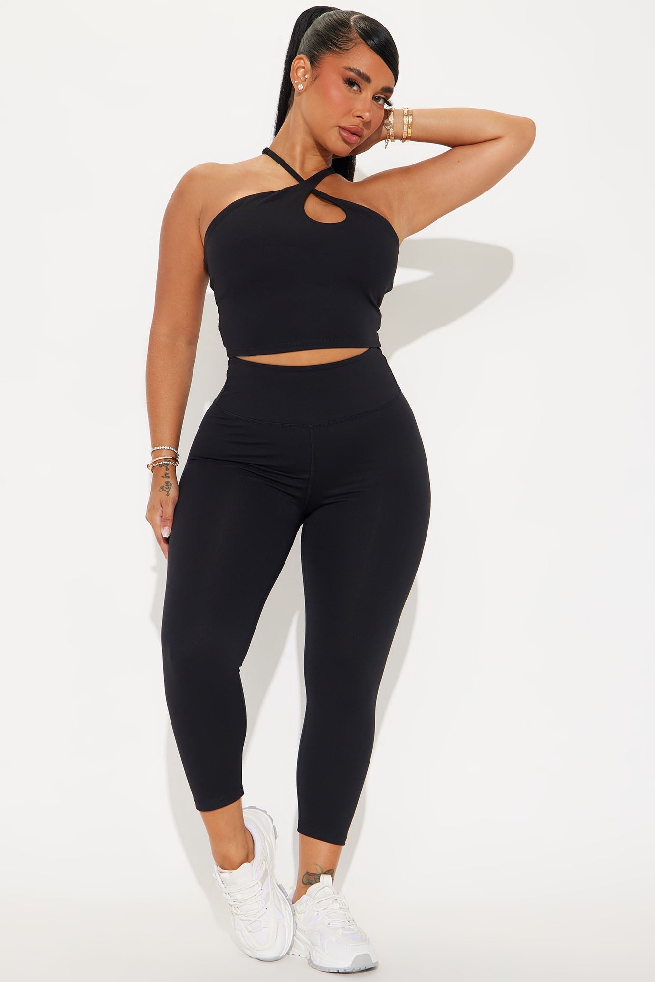 Woman in black crop top and super soft capri leggings from Fashion Nova, styled with white sneakers