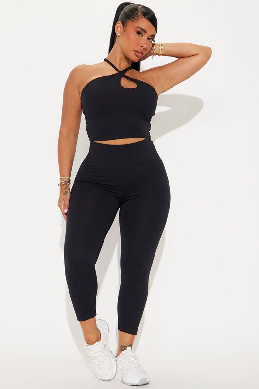 Woman in black crop top and super soft capri leggings from Fashion Nova, styled with white sneakers
