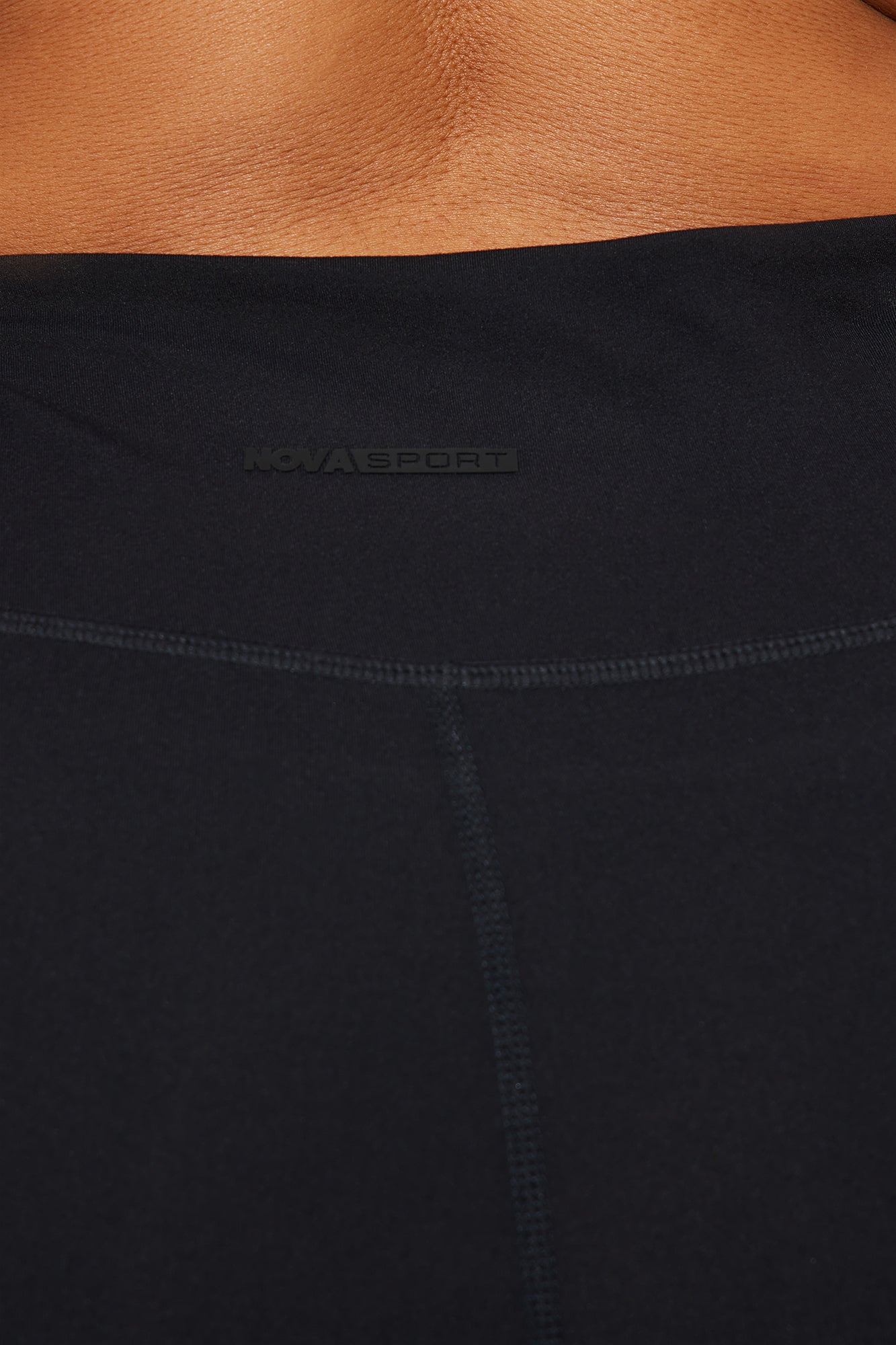 Close-up of Nova Sport logo on waistband of super soft capri leggings in black