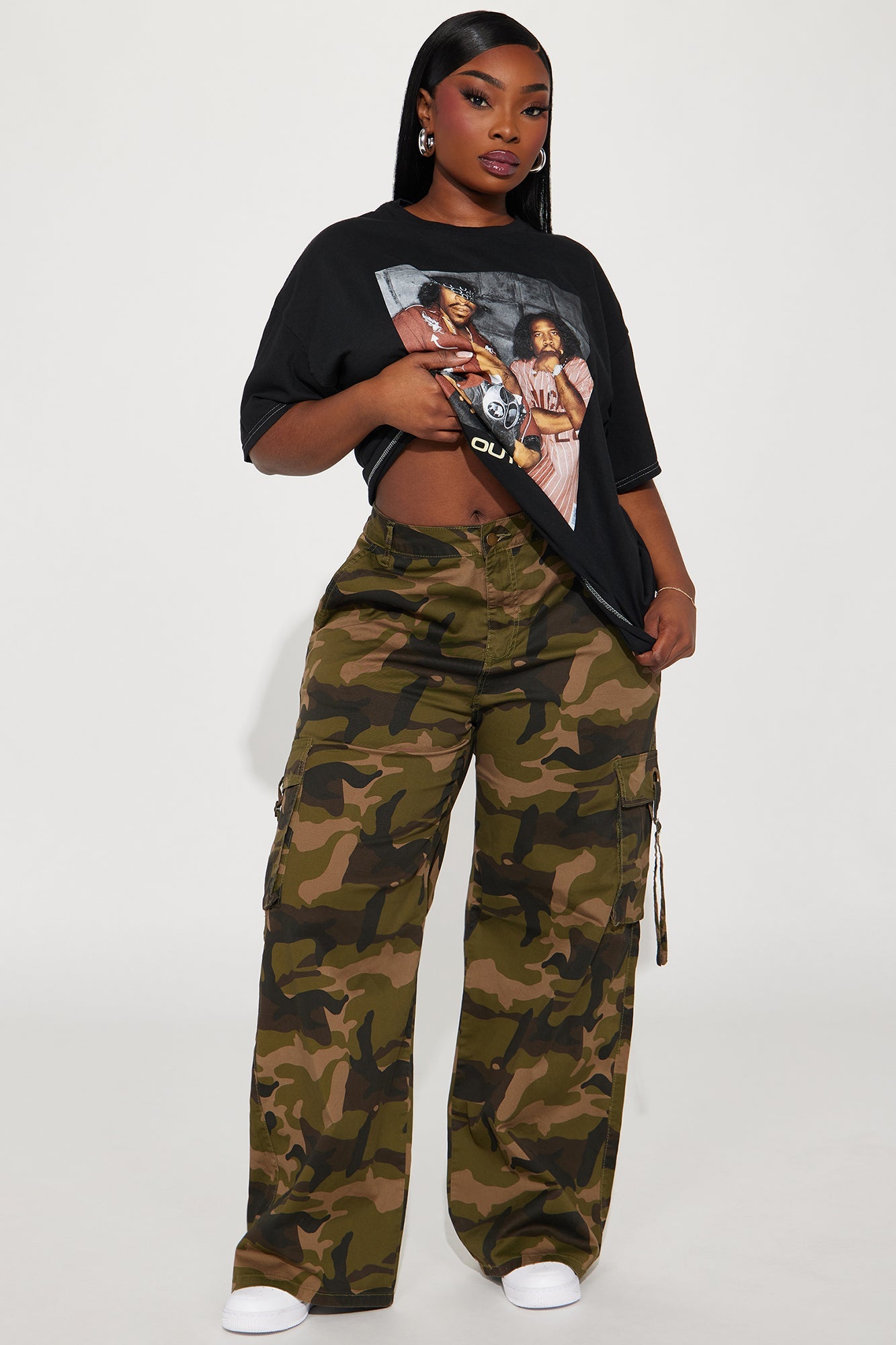 Model wearing Outkast So Fresh graphic tee with camo cargo pants for a trendy urban look