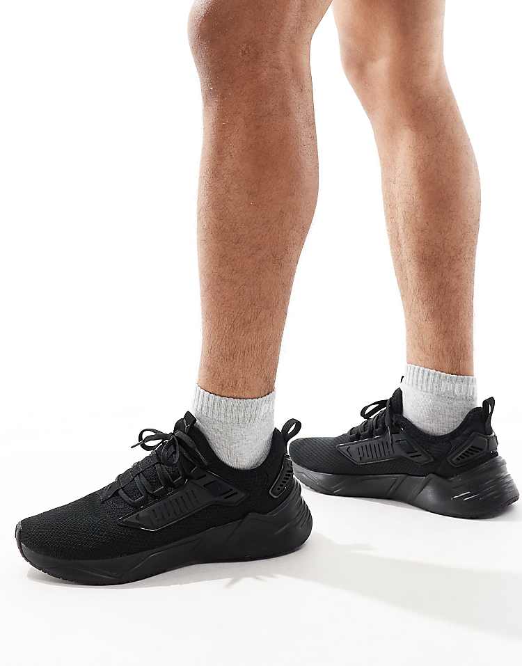 PUMA Retaliate 3 black sneakers on a model with athletic socks for a stylish look